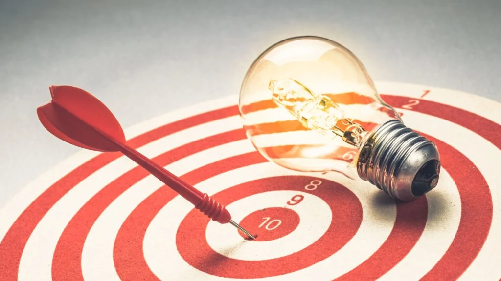 a dart pin on a dart board that hit 10 with a light bulb above the target