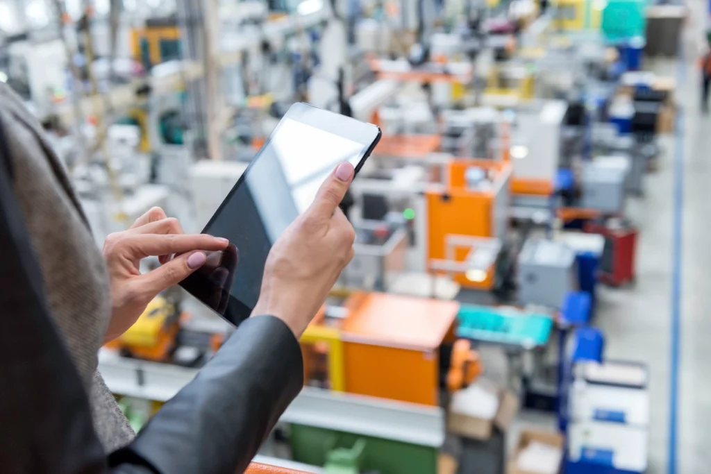 woman in a factory using a tablet with an order management system