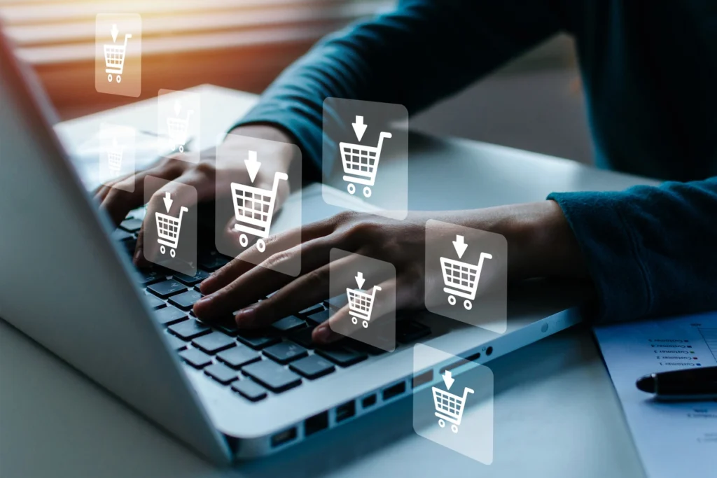 man using a laptop with hovering eCommerce cart icons as foreground